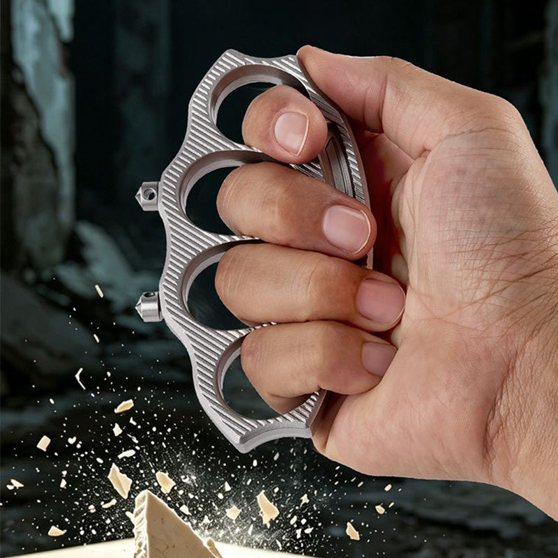 Hand gripping the knuckle duster as it shatters tile with flying fragments