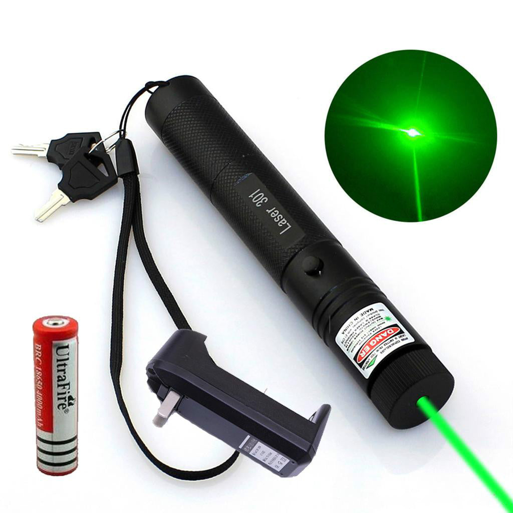 Black laser pointer pen emitting a green beam beside its battery, charger, and keys