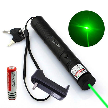 Black laser pointer pen emitting a green beam beside its battery, charger, and keys