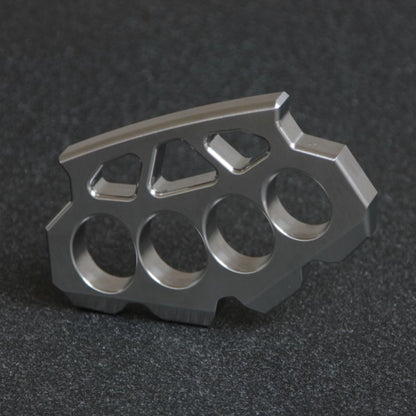 Side profile of the maple leaf shaped stainless steel knuckle duster on a dark surface.