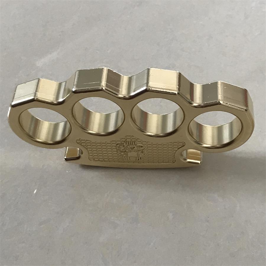 Rear view of the brass mini knuckle duster showing the scalloped upper edge above the four finger holes