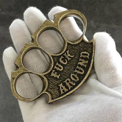 Antique copper retro knuckle duster held palm-up in a white-gloved hand