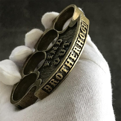 Side profile of the antique copper retro knuckle duster held in a gloved hand