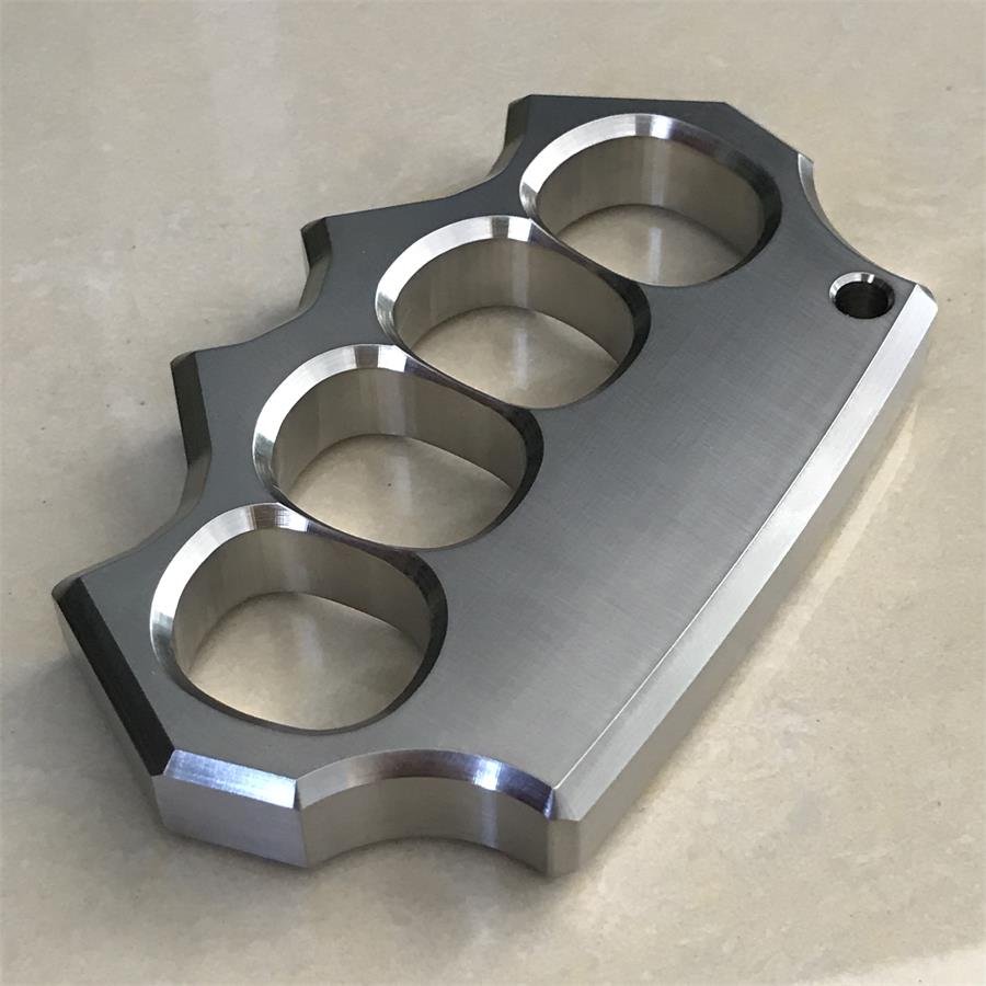 Another angled flat lay of the mirror polished four-hole stainless steel duster on beige surface.