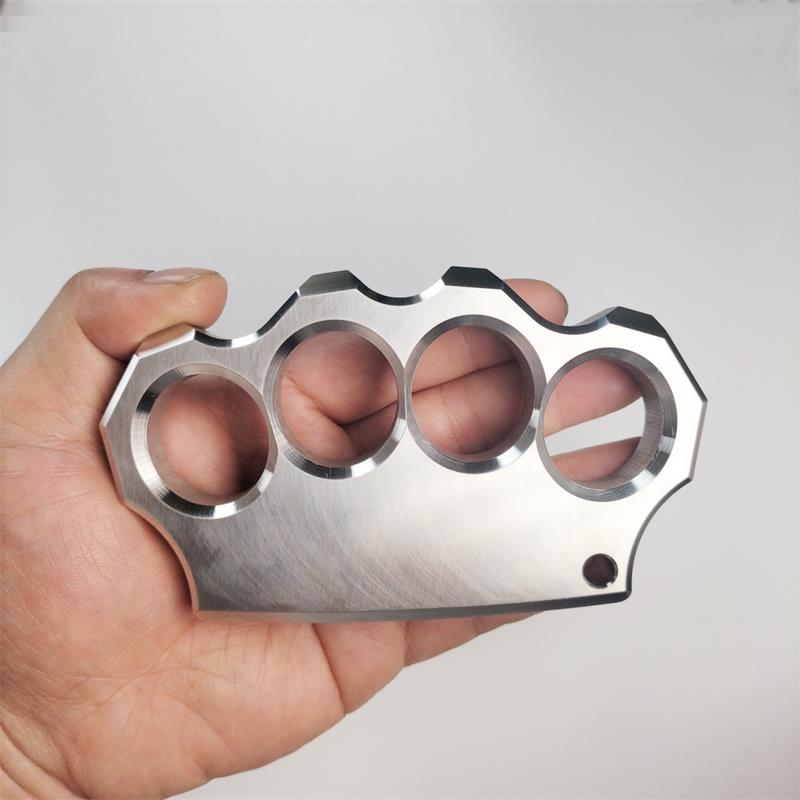 Fingers inserted through the four holes of the mirror polished stainless steel knuckle duster, grip demonstration.