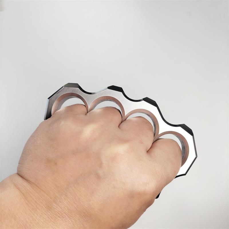 Back of a fist wearing the mirror polished four-hole stainless steel knuckle duster, top-down view.