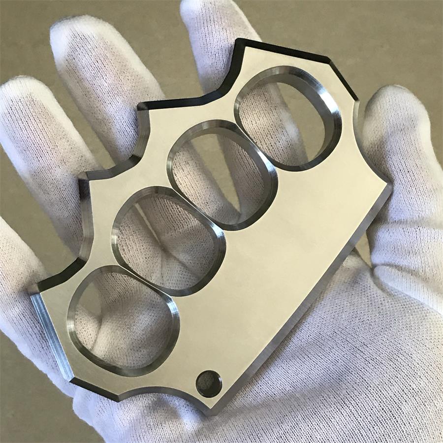 White-gloved hand holding the mirror polished four-hole duster straight on, showing hole alignment.
