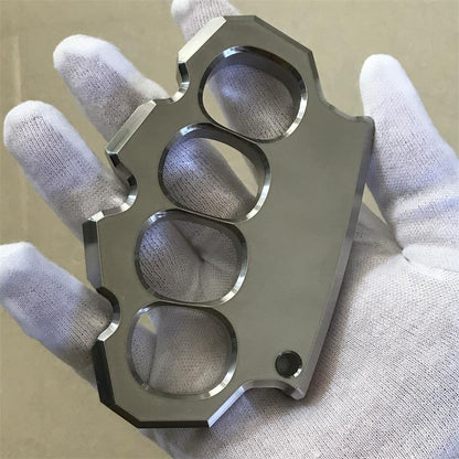 White-gloved hand holding the mirror polished four-hole duster at a three-quarter angle.