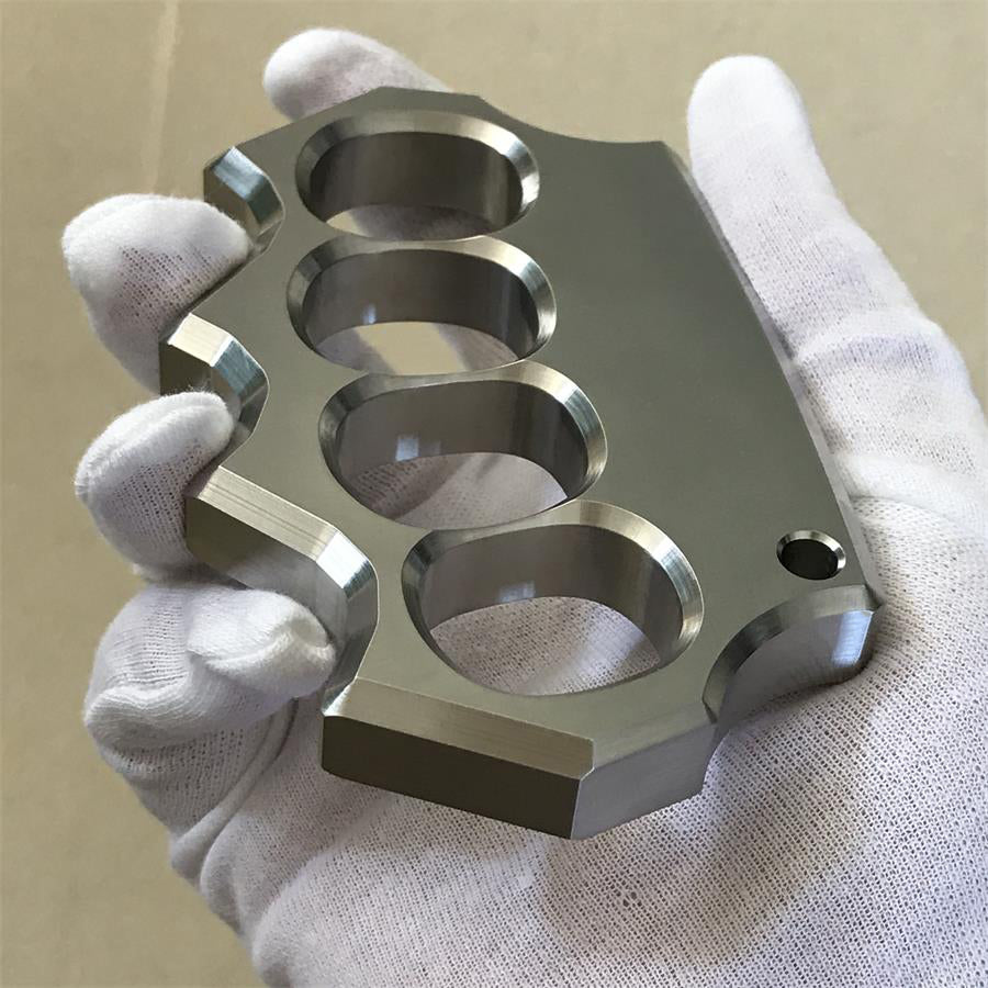 White-gloved hand holding the mirror polished four-hole stainless steel duster from below.