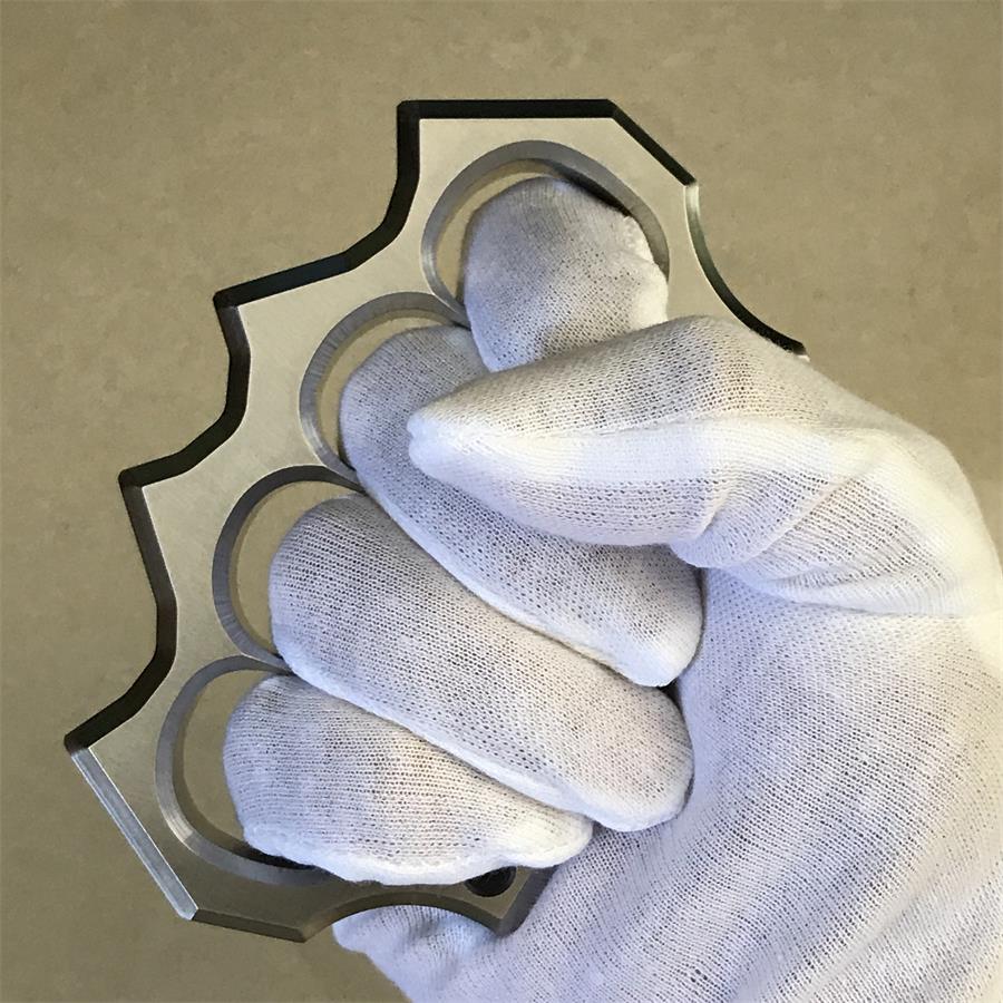 White-gloved fingers gripping the side of the mirror polished four-hole stainless steel duster.