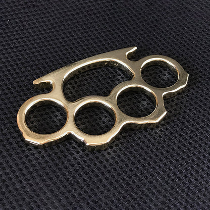 Brass gold knuckle duster flat lay on black textured surface