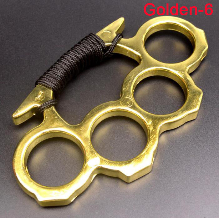 Golden knuckle duster with black paracord grip held by hand