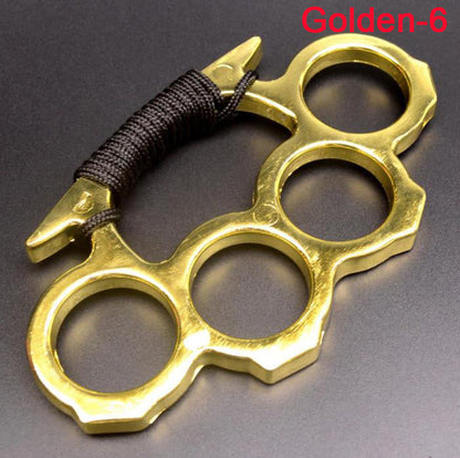 Golden knuckle duster with black paracord grip held by hand