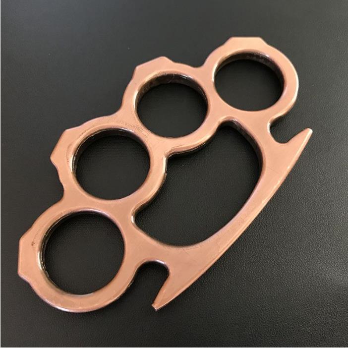 Rose gold copper knuckle duster flat lay on dark background