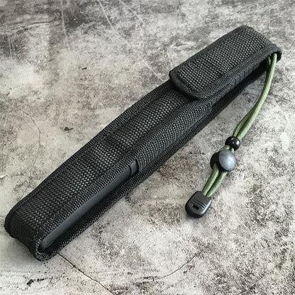 Black nylon pouch lying on a concrete floor with the green cord and toggle out