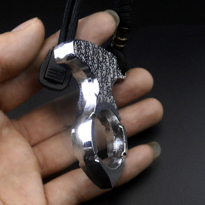 Back view of the one finger knuckle showing the polished ring band with notches, embossed plate and black cord toggle on a dark background