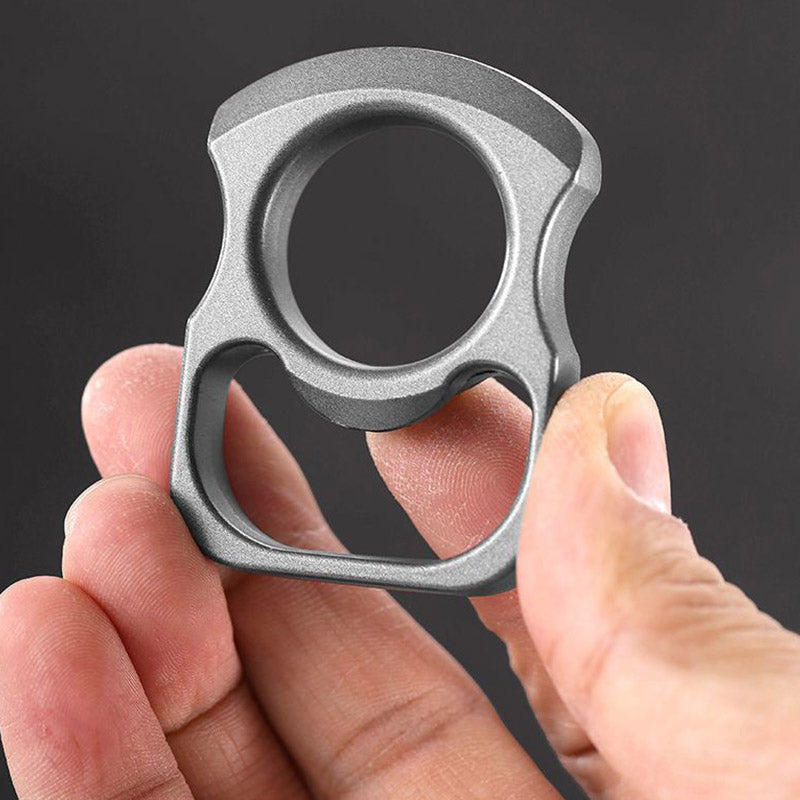 Fingers gripping the grey zinc alloy opener tool in a close view of the matte finish
