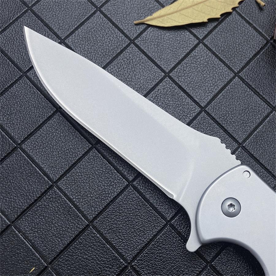 Close-up of the drop-point blade showing the grind and serrated thumb ramp near the steel handle