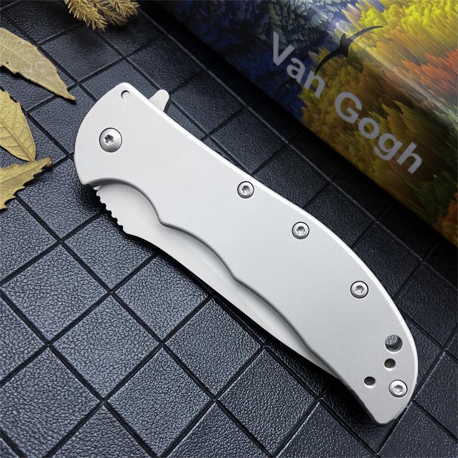 Closed folding knife with contoured all-steel handle and hex screws beside a colourful printed box