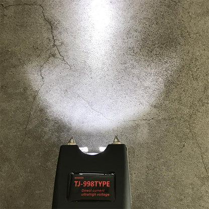 Close view of the black unit head with a bright LED beam cast on concrete and the red TJ-998TYPE label panel below the twin pins