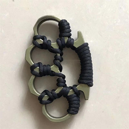 Flat view of the woven knuckle duster with a pale metallic frame and black umbrella rope wrapping on a plain background