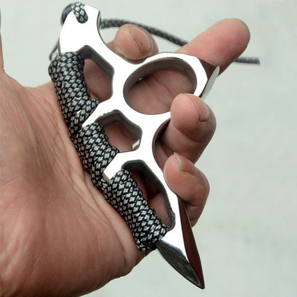 Paracord-wrapped silver steel knuckle duster worn in a closed-hand grip with the lanyard trailing behind