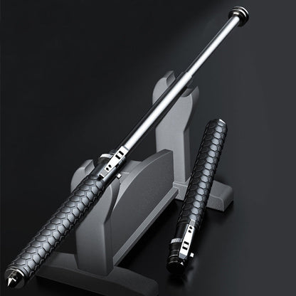 Extended pen-shaped baton resting on a grey display stand beside a closed one with a hexagon-textured handle