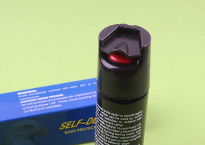 Close-up of pepper spray canister flip-top cap and red nozzle