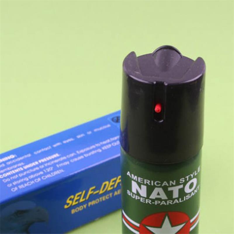 Close-up of the black flip-top safety cap and red actuator on the green pepper spray can