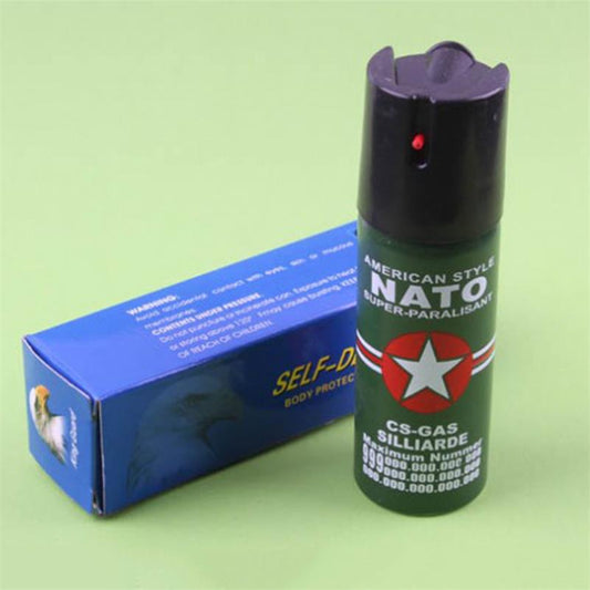 Green pepper spray can standing upright beside a blue body protect aerosol box on a green background