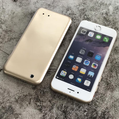 Top-down view of the gold phone-shaped device beside a white smartphone showing the smooth back with a small round hole and two tiny holes