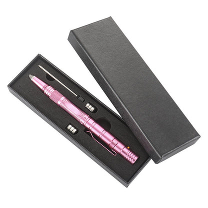 A pink tactical pen presented in an open black gift box with a cut-foam insert holding the pen alongside spare AG10 button batteries and a refill, on a white background.