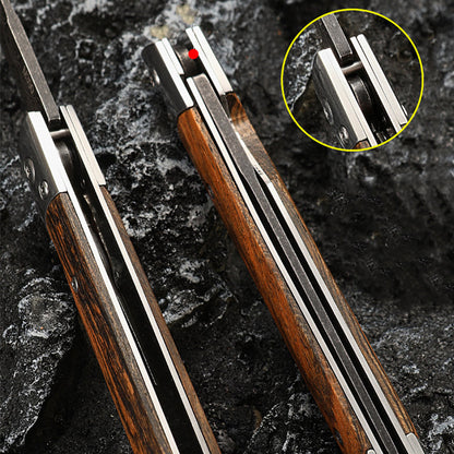 Close-up of two folded knives showing the pivot area and Damascus pattern in the fold, with an inset circle highlighting the pivot screw detail, on dark rock