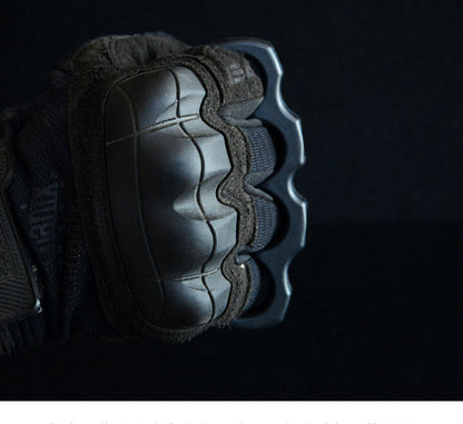 Gloved fist wearing the black polymer knuckle duster with the finger holes seated around the knuckles