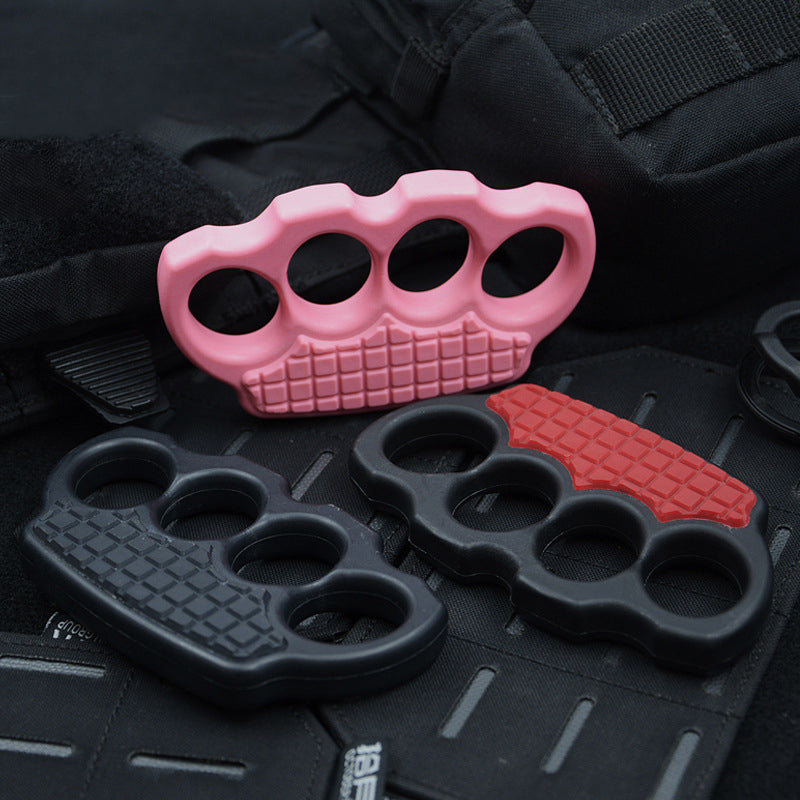 Pink, black and red-black knuckle dusters leaning on black tactical gear with a backpack above