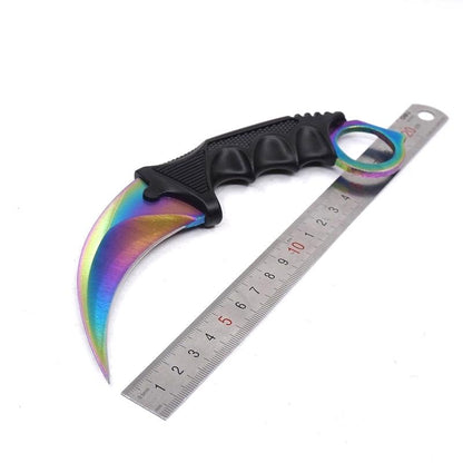 Single rainbow one-hole karambit knife displayed next to a metal ruler