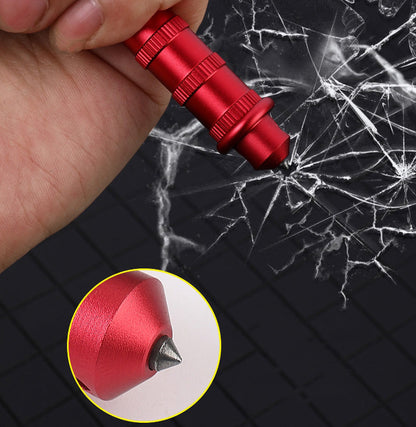 Red keychain dagger pressed against shattered glass in a hand, showing the tail window-break tip, with a close-up inset of the pointed tip.