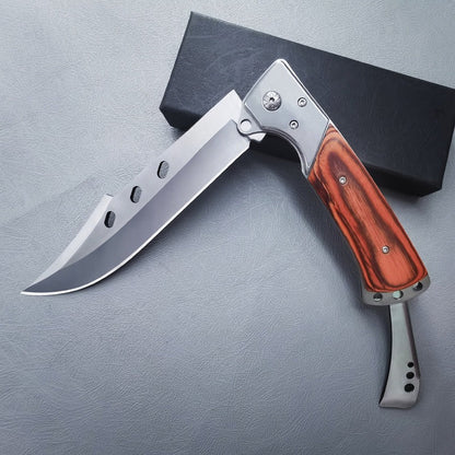 Redwood handle folding knife fully open with blade pointing left and black box behind