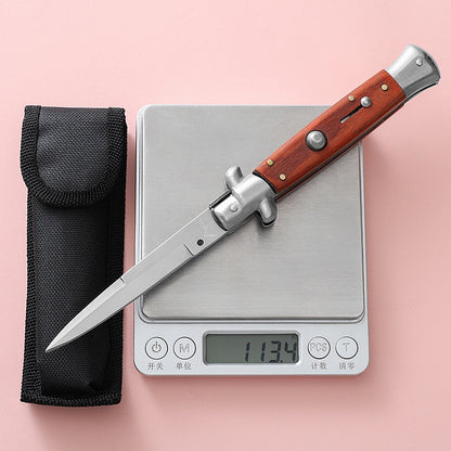 Folding knife on digital pocket scale showing weight next to black sheath