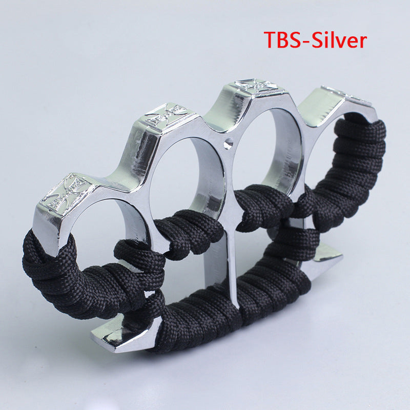 Silver three-hole knuckle duster with black paracord grip and embossed crosses on white background