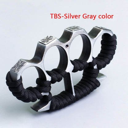 Silver gray three-hole knuckle duster with black paracord grip on white background