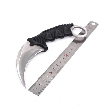 Single silver one-hole karambit knife displayed next to a metal ruler