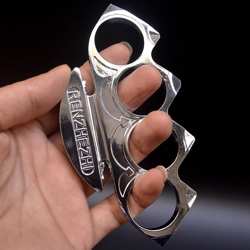 Silver knuckle duster worn on the fingers showing the round holes and engraved face