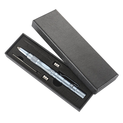 A silver tactical pen presented in an open black gift box with a cut-foam insert holding the pen alongside spare AG10 button batteries and a refill, on a white background.