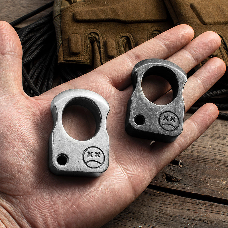 Light and dark single-hole knuckle weights resting in an open palm