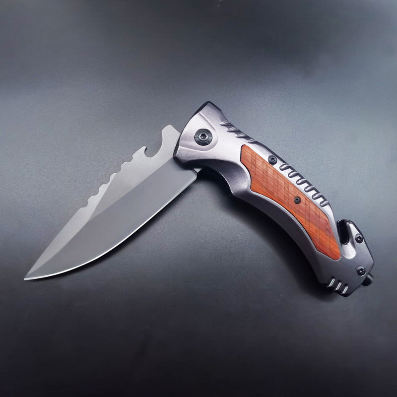Single open multifunctional folding knife with wood inlay on dark background