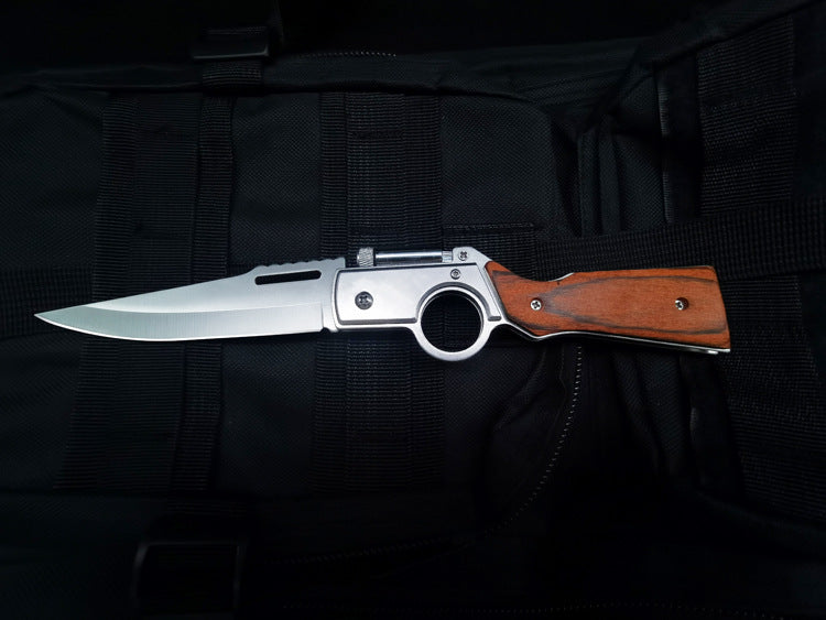 Single open wood-handle folding knife on black tactical fabric
