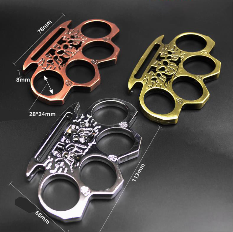 Three skeleton knuckle dusters in rose gold, bronze and silver with dimension marks for the 113mm length and 78mm palm rest