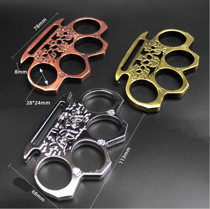 Three skeleton knuckle dusters in rose gold, bronze and silver with dimension marks for the 113mm length and 78mm palm rest