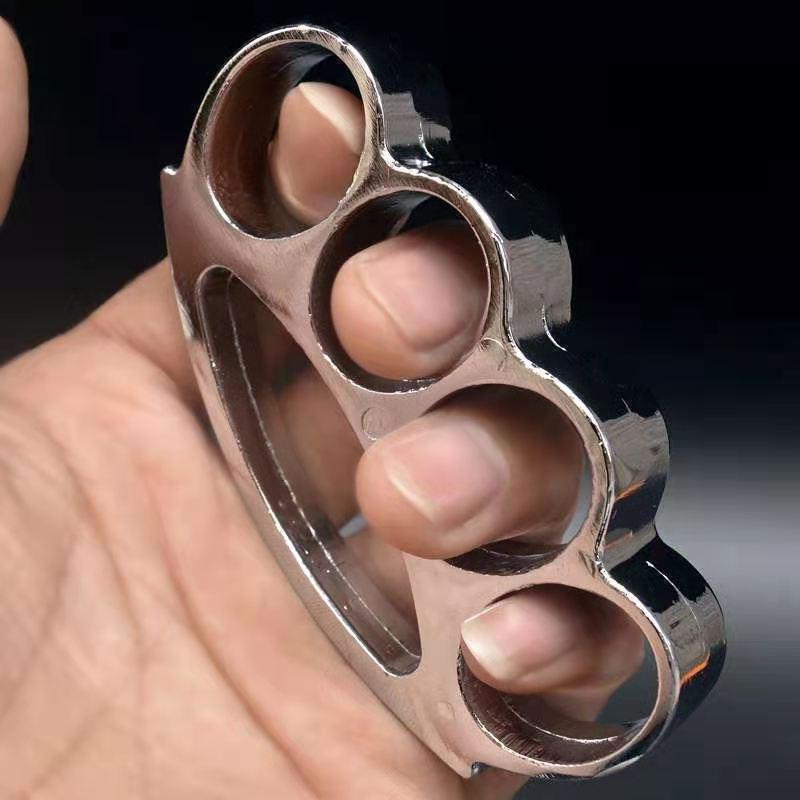 Silver chrome smile-hole zinc alloy knuckle duster held in hand showing side profile